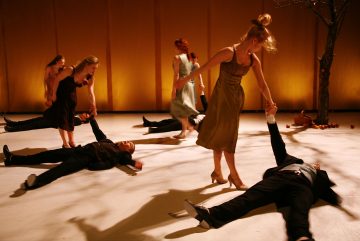 Lavalla esiintyy kuusi ihmistä; kolme pukuun pukeutunutta naista seisoo tai polvistuu ja kolme pukuun pukeutunutta miestä makaa lattialla. Yksi nainen auttaa miestä ylös. Valaistus on lämmin, ja kohtauksen reunalla seisoo paljas puu.