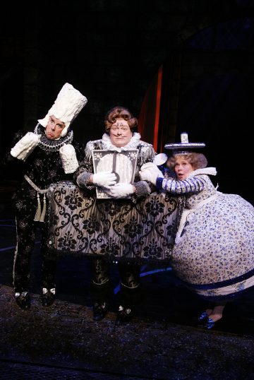 Lavalla esiintyy kolme näyttelijää taidokkaissa, omituisissa puvuissa: yksi kynttilänjalkaisena, yksi kellona ja yksi teekannuna. He poseeraavat yhdessä tummaa taustaa vasten, mikä tuo mieleen teatraalisen satuympäristön.