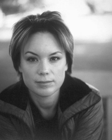 Mustavalkoinen muotokuva henkilöstä, jolla on lyhyet hiukset, takki päällään ja joka katsoo suoraan kameraan neutraalilla ilmeellä. Tausta on pehmeästi sumea.