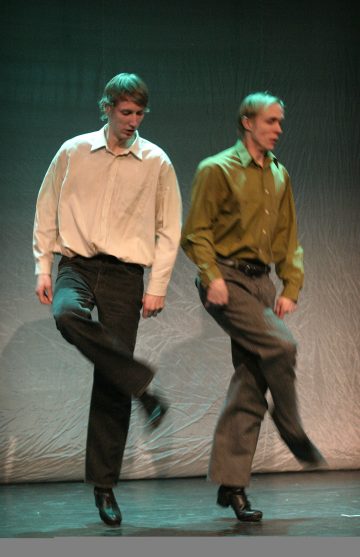 Pari miestä tanssii lavalla.