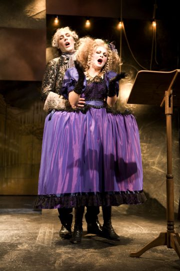 Lavalla esiintyy kaksi näyttelijää, jotka ovat pukeutuneet hienostuneisiin aikakauden pukuihin; mies seisoo naisen takana syleillen tätä, ja nainen laulaa nuottipöydältä yllään suuri violetti mekko ja mustat hansikkaat.