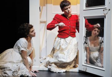 Lavalla esiintyy kaksi aikakauden pukuihin pukeutunutta naista, joista toinen polvistuu lattialle ja katsoo ylöspäin, kun taas toinen, punatakkinen nainen istuu oven vieressä pitelemässä ruoskaa muistuttavaa esinettä ja katselee peilikuvaansa peilipaneelissa.