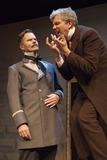 Lavalla esiintyy kaksi aikakauden pukuihin pukeutunutta miestä, joista toinen seisoo pystyssä tiukka ilme kasvoillaan, kun taas toinen nojautuu häntä kohti eloisasti ja intohimoisesti elehtien. Tausta on yksinkertainen ja teatraalinen.