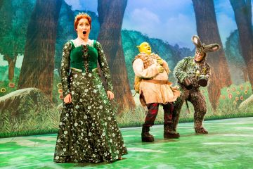 Lavalla esiintyy kolme näyttelijää: yksi prinsessa Fiona vihreässä mekossa, yksi Shrek beigeen tunikaan pukeutuneena ja yksi Aasi karvaisessa puvussa. Heidän takanaan on maalattu metsätausta.