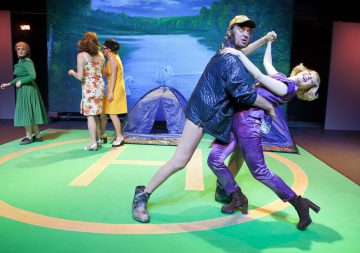 Mies pitelee naista lavalla.