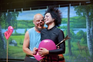 Lavalla esiintyy kaksi näyttelijää; toisella on sian nenä ja sininen paita, ja hän halaa toista mustapukuista, piikkihiuksin varustettua näyttelijää, jolla on kädessään vaaleanpunainen sydän, jonka on lävistänyt nuoli. Taustalla on maalattu metsätausta ja sydämenmuotoinen ilmapallo.