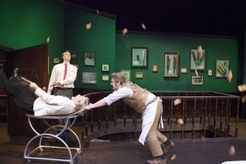 Lavalla esiintyy kaksi näyttelijää; toinen valkoiseen paitaan pukeutunut mies makaa liikkuvalla metallisella parturituolilla, kun toinen parturiksi pukeutunut mies työntää häntä. Kolmas mies seisoo katsomassa. Kehystetyt kuvat ja roskat täyttävät viherseinäisen taustan.