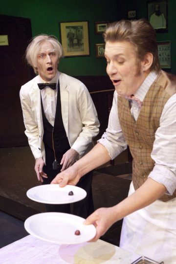 Lavalla esiintyy kaksi vintage-asuihin pukeutunutta miestä; toinen valkoiseen takkiin ja rusettisolmioon pukeutuneista näyttää yllättyneeltä, kun taas toinen, liiviin ja rusettisolmioon pukeutunut mies esittelee kaksi lautasta, joissa kummassakin on yksi pieni ruoka-annos.
