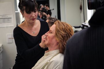 Maskeeraaja meikkaa esiintyjää