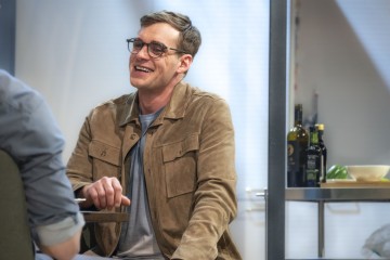 Mies istuu pöydän ääressä.