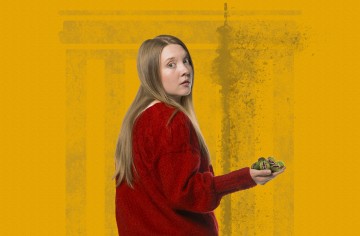 Pitkät vaaleat hiukset omaava nainen, jolla on punainen villapaita, katsoo olkansa yli ja pitää kädessään kahta pientä vihreää leludinosaurusta, jotka seisovat keltaisella taustalla, jossa on abstrakti kuvio.