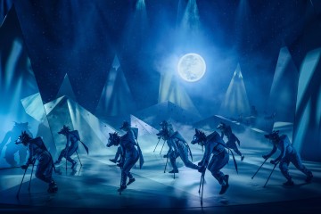 Sudenpukuiset esiintyjät tanssivat sinisellä valaistulla näyttämöllä, jossa on vuorenmuotoisia rekvisiittaa, kirkkaan täysikuun alla, joka heijastuu tähtitaustalle. Kohtaus herättää mystisen, talvisen yön tunnelman.