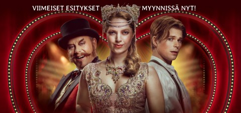 Kolme hienostuneisiin sirkustyylisiin pukuihin pukeutunutta ihmistä seisoo punaisen, kullanvärisen taustan edessä, ja heidän yläpuolellaan on suomenkielinen teksti. Keskellä olevalla naisella on jalokivikruunu; kaksi miestä seisoo molemmin puolin, toinen hymyillen ja toinen vakavana.