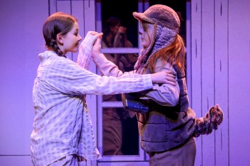 Lavalla esiintyy kaksi pukumiestä, joista toisella on pyjama ja punottu tukka, ja toisella on korvaläpällinen karvahattu, liivi ja häntä. He seisovat vastakkain, kädestä pitäen, ja heidän takanaan on ikkunatausta.