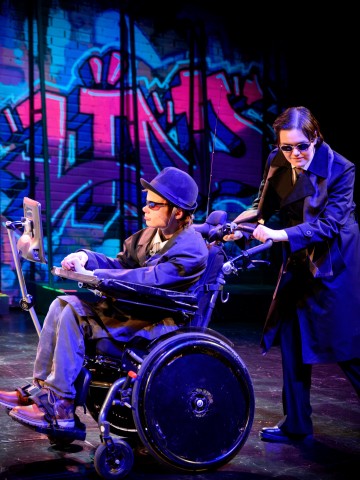 Lavalla esiintyy kaksi tummiin vaatteisiin ja aurinkolaseihin pukeutunutta näyttelijää; toinen istuu moottoroidussa pyörätuolissa ja käyttää laitetta, kun taas toinen seisoo takana kumartuneena. Taustaa koristaa värikäs graffitiseinämaali.